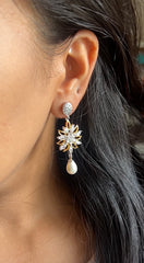 Flower danglers with oval studs and a pearl drop in two tone look made in pure silver with 22 kt. gold plating