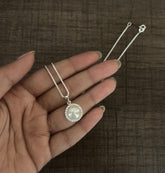 1.4 cm diameter pearl pendant with a multiple cz stone border and an 18’’ chain in pure silver