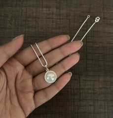 1.4 cm diameter pearl pendant with a multiple cz stone border and an 18’’ chain in pure silver