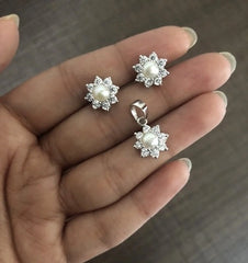 Compact 9mm diameter flower cz stone earrings and pendant set with a pearl center in pure silver